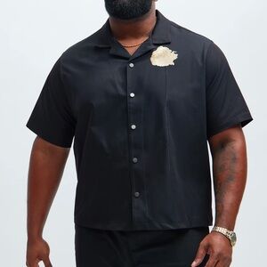 Solid material textured black short sleeve shirt. Available now